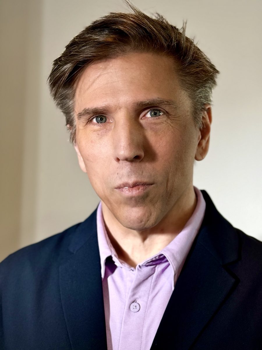 Rob Schreiber wearing a navy blazer and light purple shirt